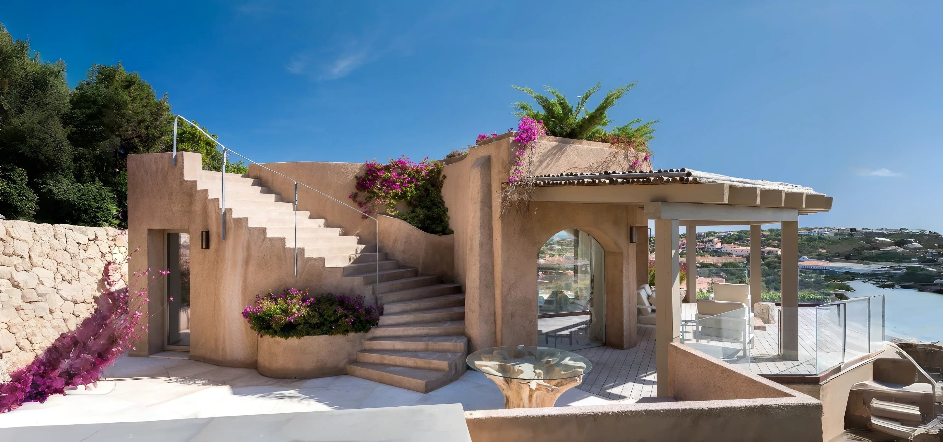 Mediterranean villa with an external stone staircase and flowering bougainvillea, overlooking the Costa Smeralda in northern Sardinia
